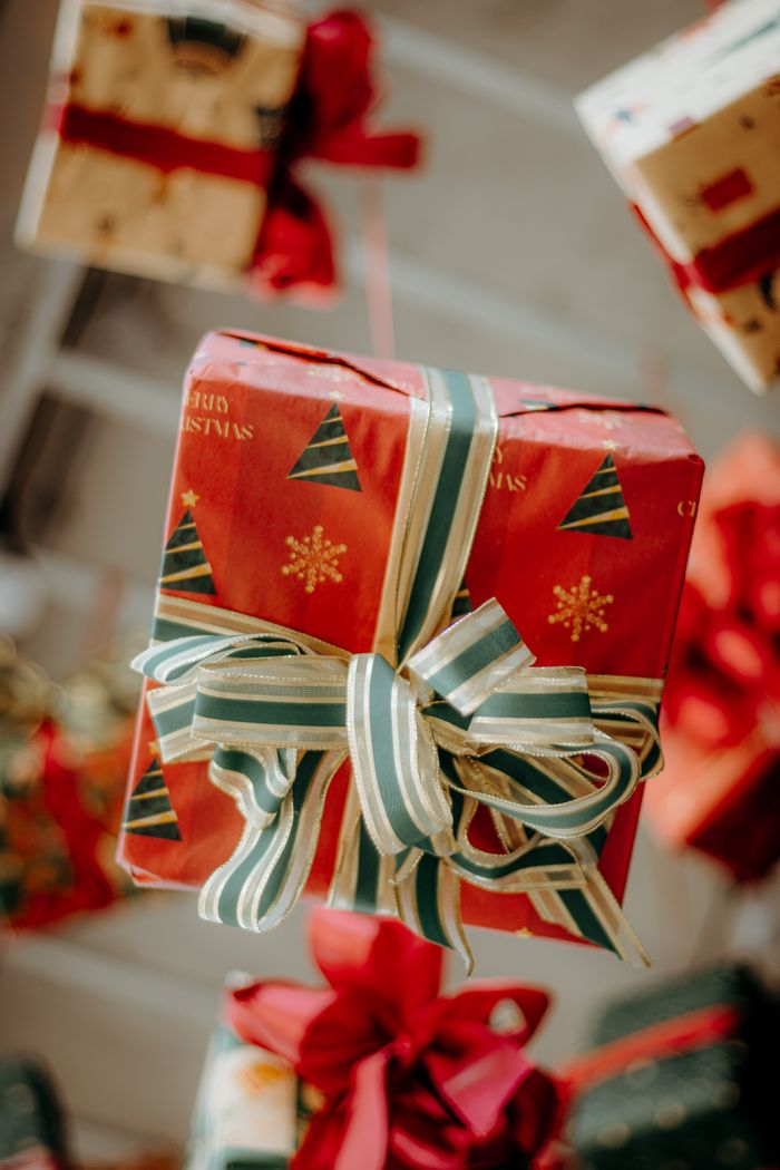 Close-up of a beautifully wrapped Christmas gift with decorative ribbon, perfect for holiday themes.