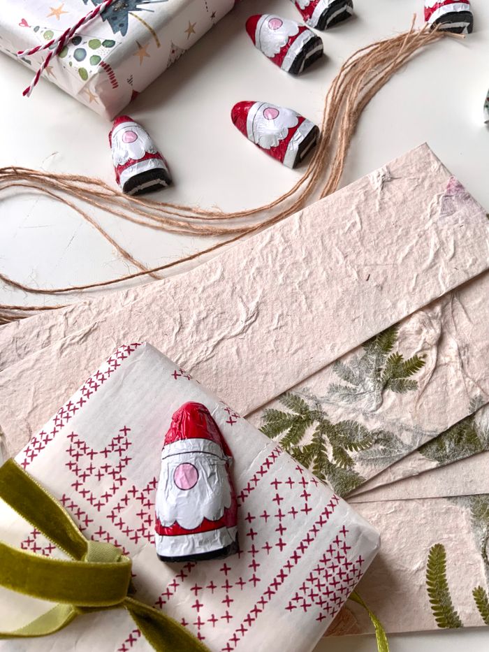 about-us Charming holiday scene with wrapped gifts and chocolate Santa decorations.