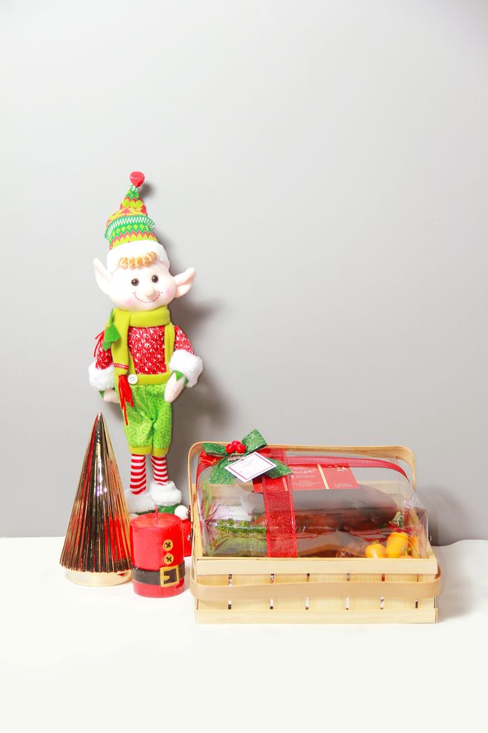 Festive elf decor with a Christmas gift basket on a white background, perfect for holiday celebrations.